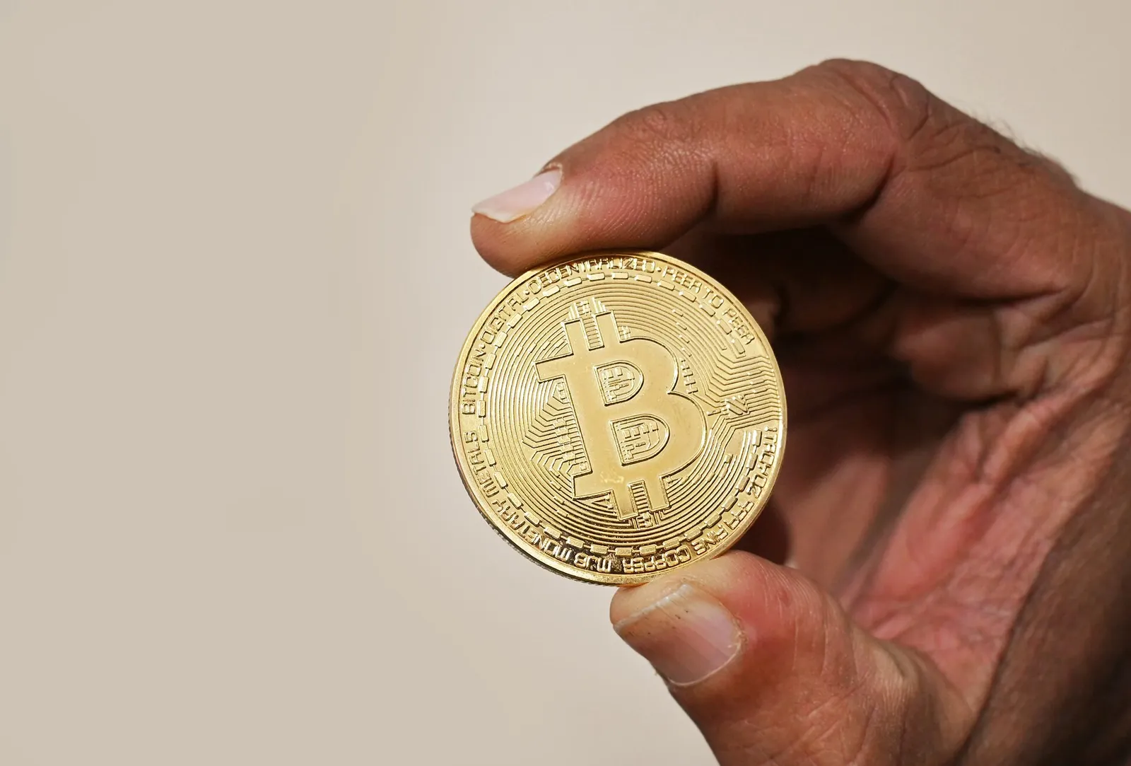 A hand holding a physical bitcoin token