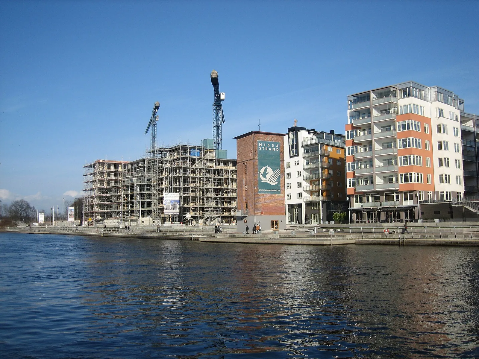Apartment buildings under construction with a tower crane above the site