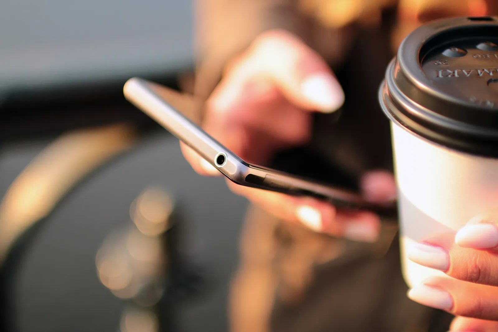 A person holding a smartphone at a table