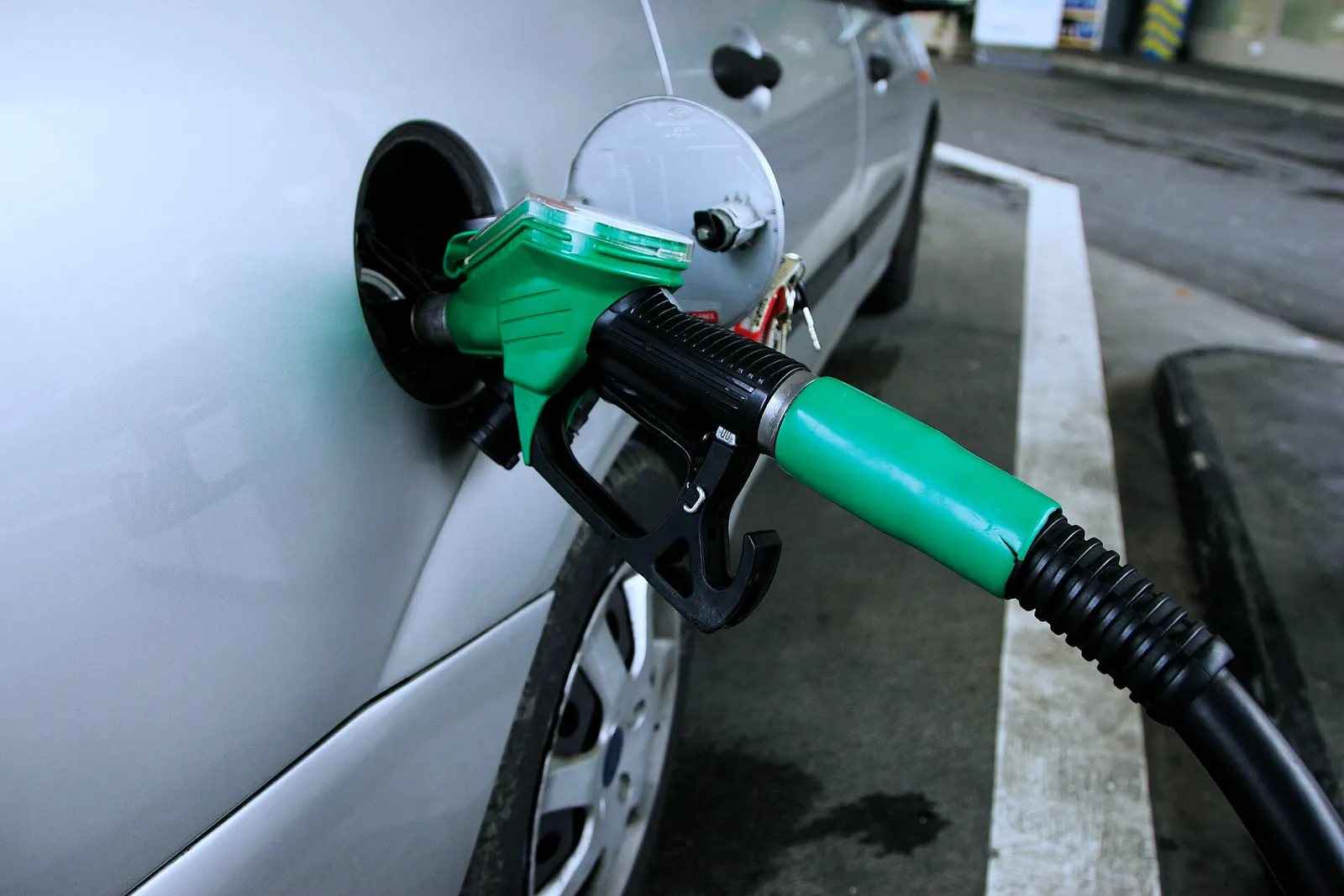 A fuel nozzle filling a car at a service station