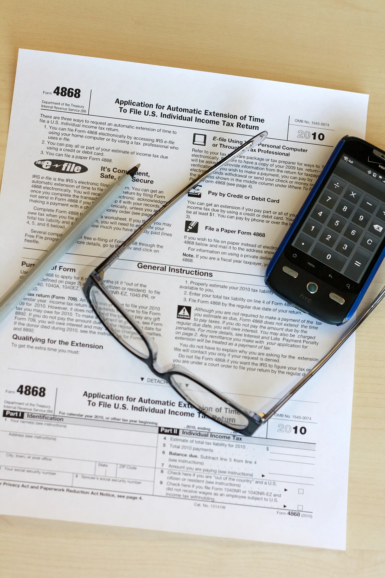 A US tax form on a desk with a pen and glasses
