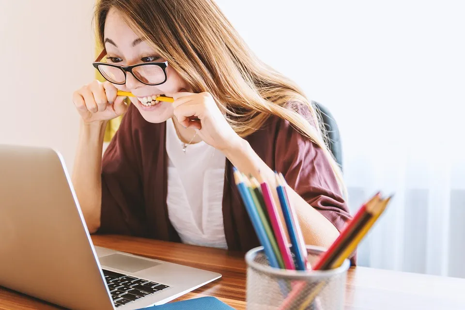 A young person at a laptop looking anxious