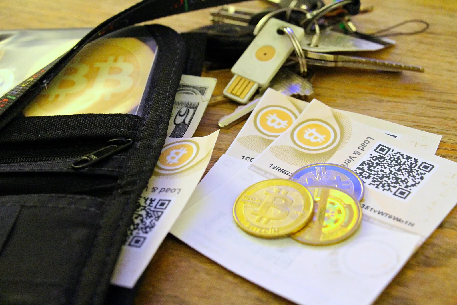 Physical coins representing cryptocurrencies alongside cash