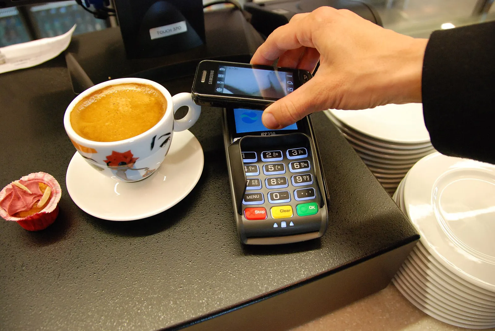 A customer making a mobile payment at a checkout terminal