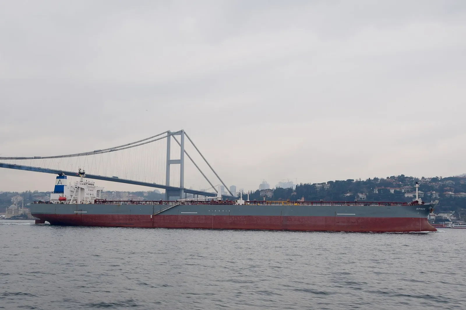 A crude oil tanker transits a narrow strait
