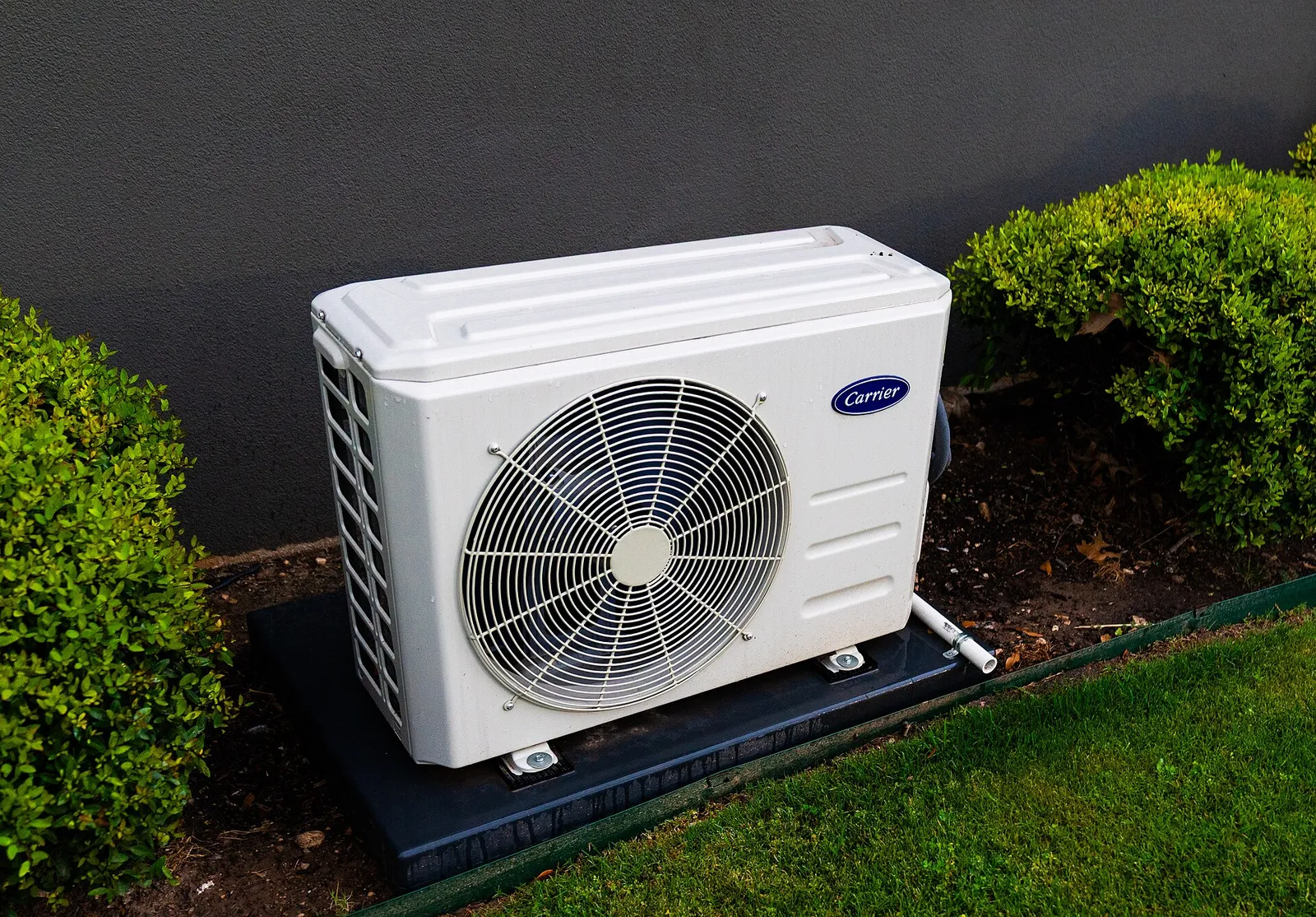An outdoor heat pump unit beside a house