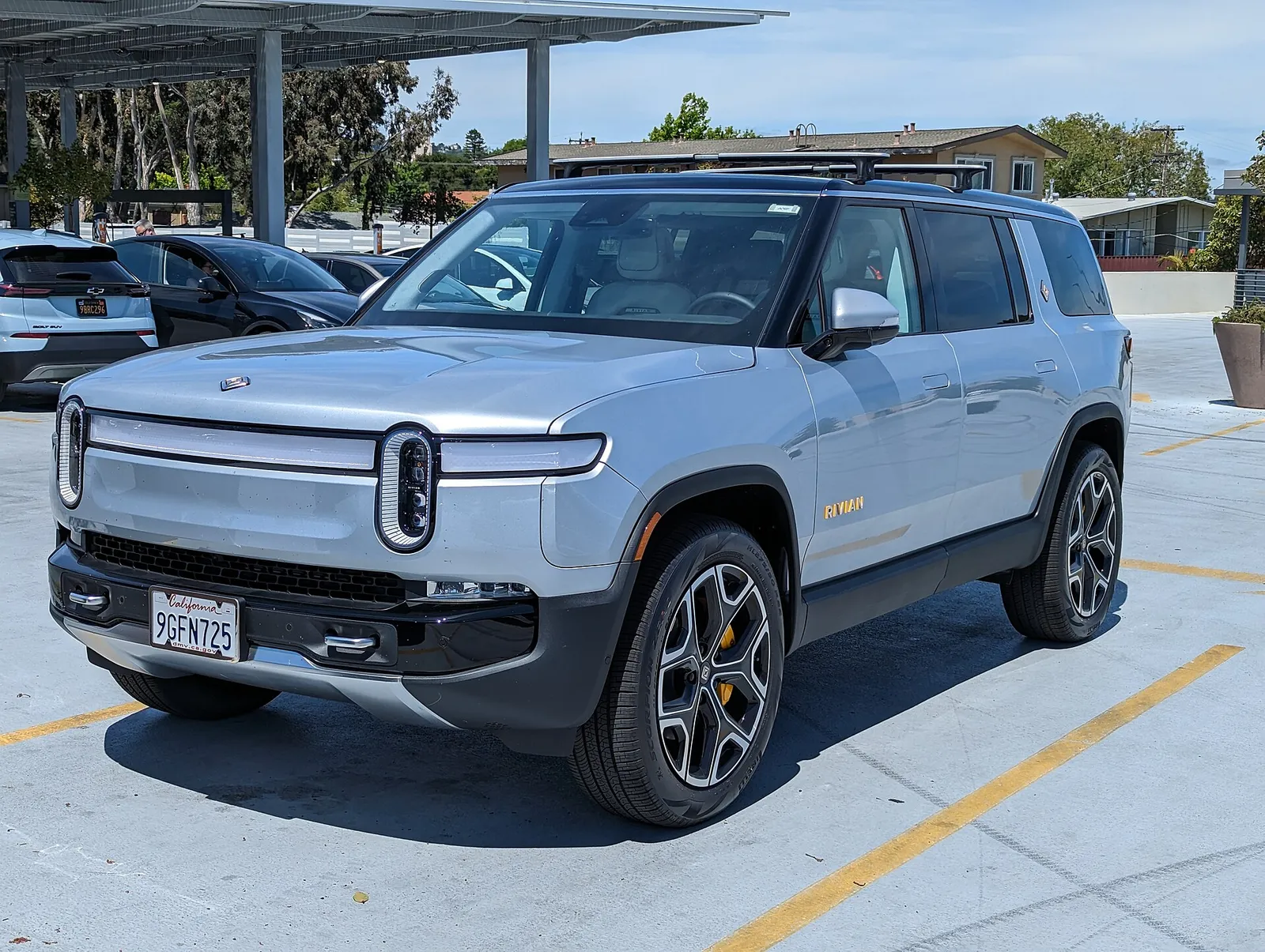 A Rivian R1S electric SUV parked outside a shopping center