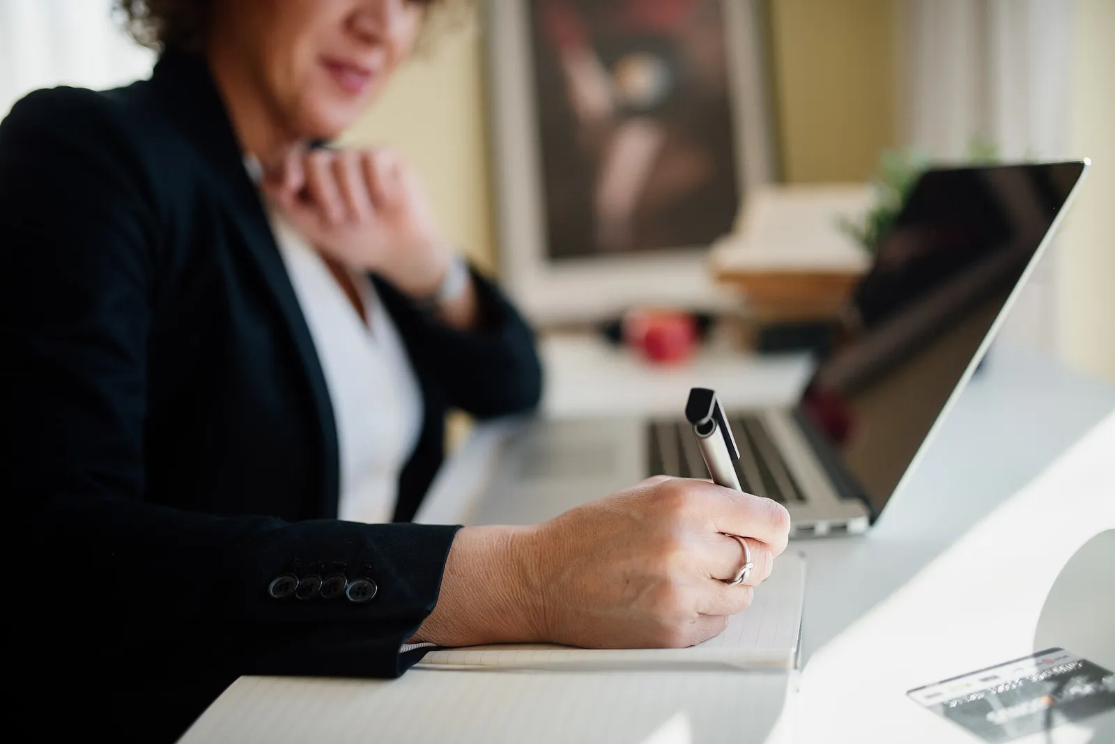 A professional taking notes at a desk during a meeting