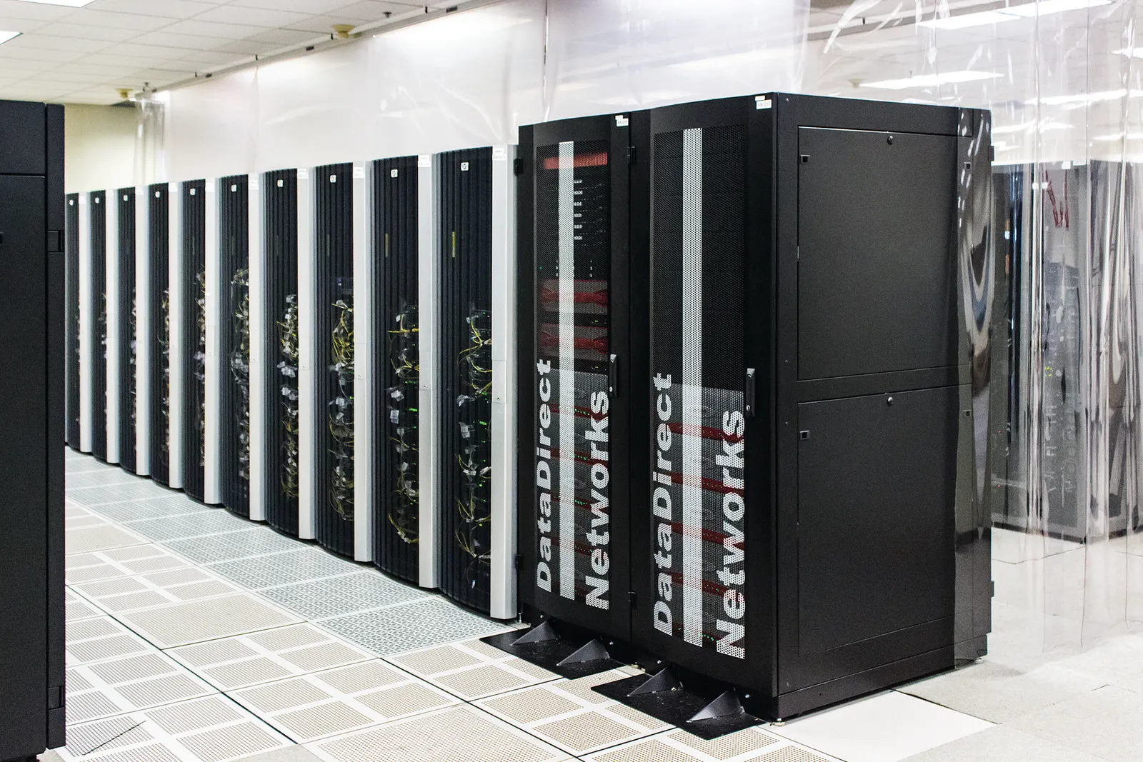 Rows of server cabinets in a supercomputing center machine hall