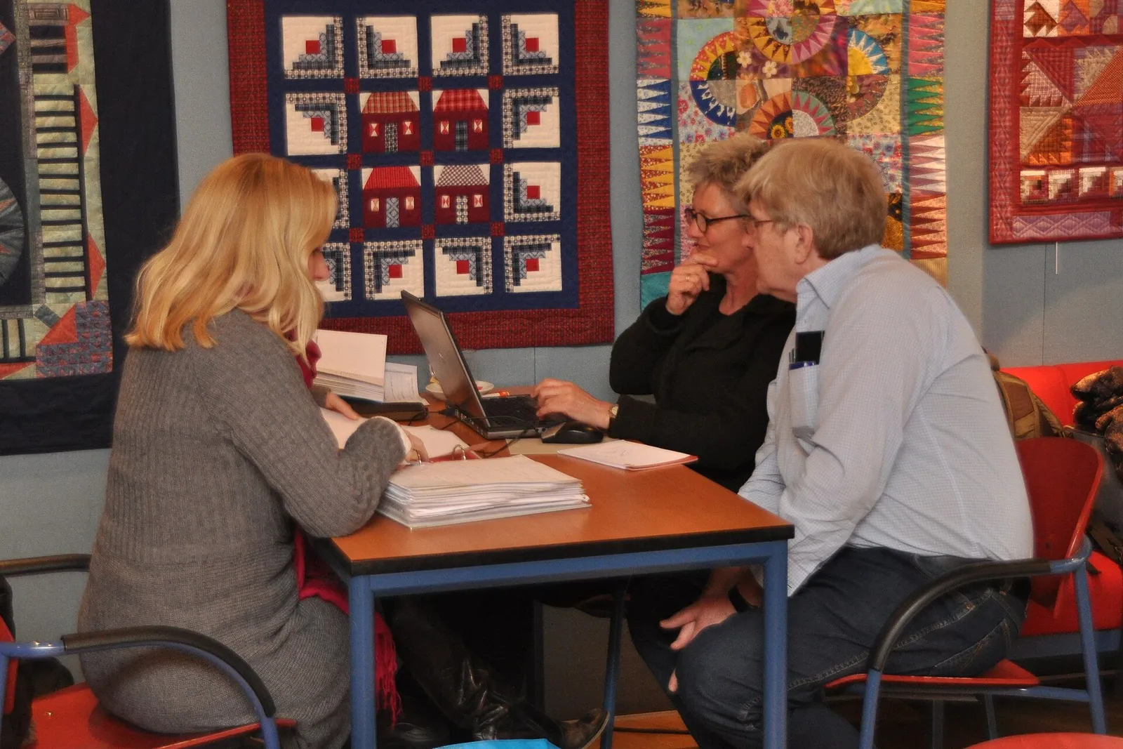 People going through financial paperwork together at a desk