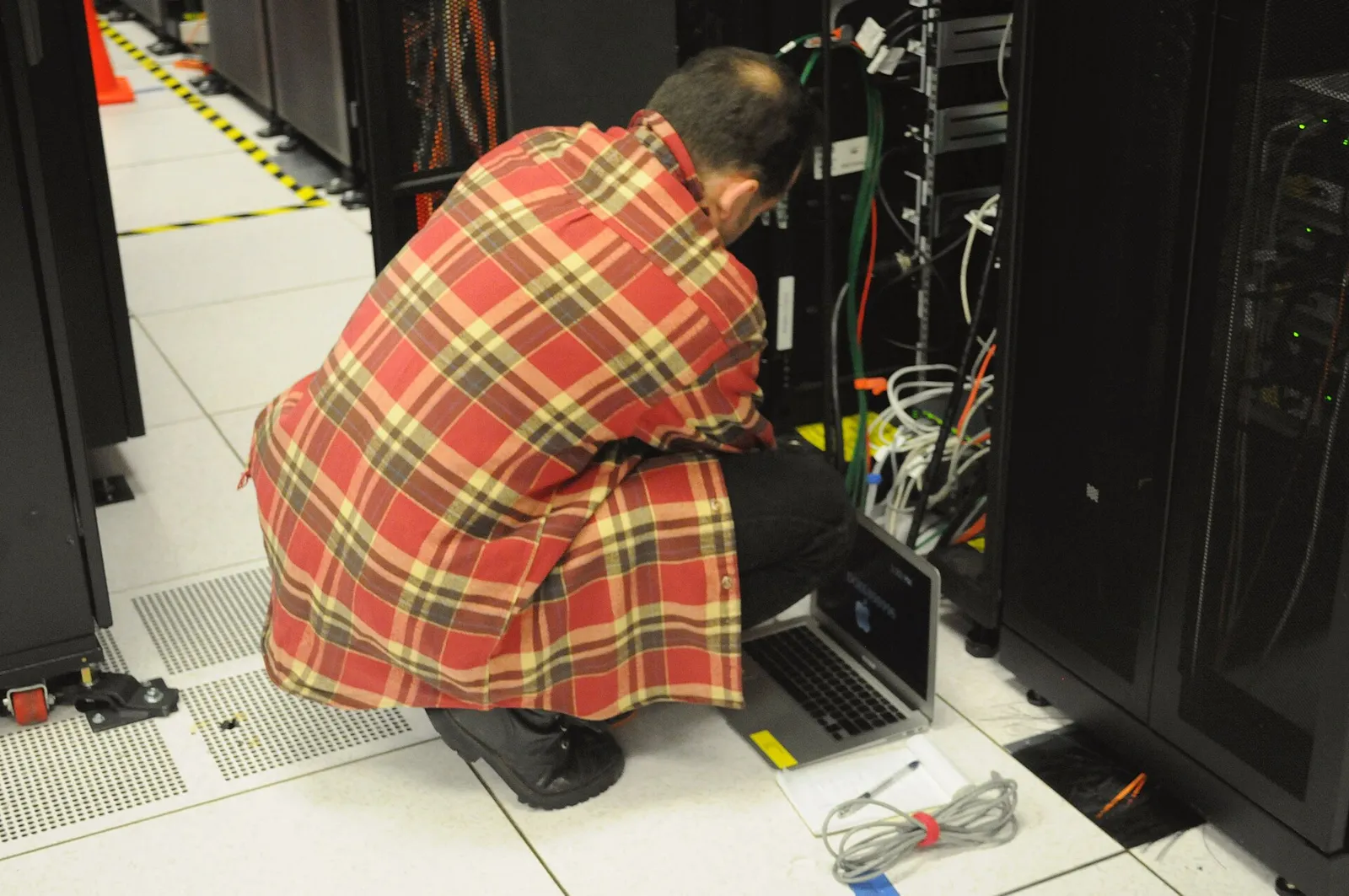 A technician working on server racks in a data center